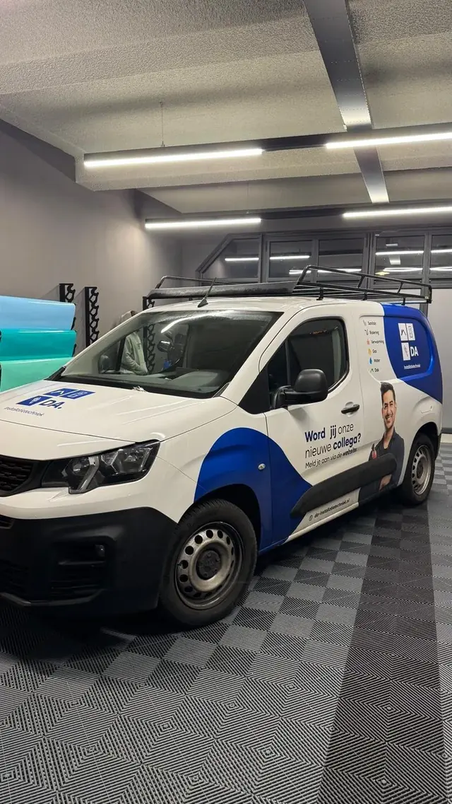 Bestelauto DA Installatietechniek — Peugeot Partner met fotowrap medewerker en blauw-wit huisstijl